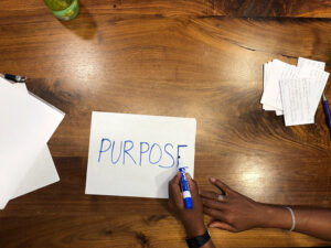 girl writing purpose on piece of paper